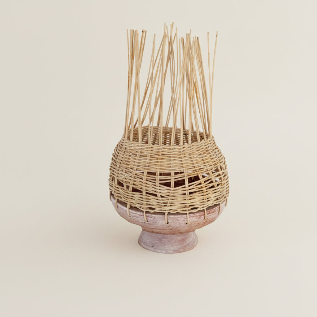 Woven basket with reeds on a textured white wall
