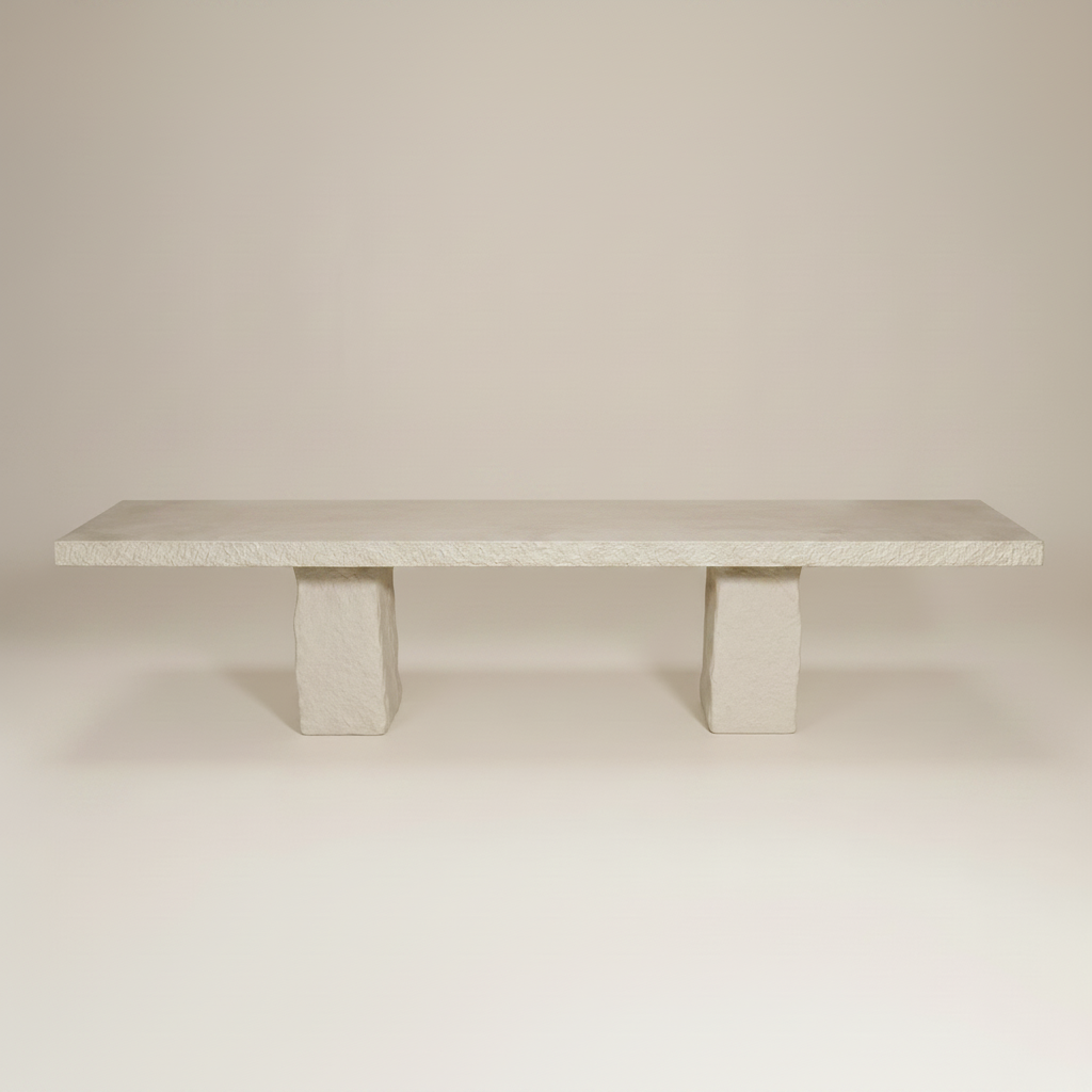A minimalist GRC 3 x 1m dining table with a textured cream top and two matching block-style legs, photographed against a neutral light beige studio background.