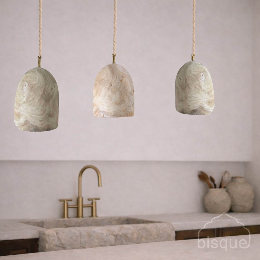 Three onyx dome pendant lights hanging above a kitchen sink with 'bisque' branding.
