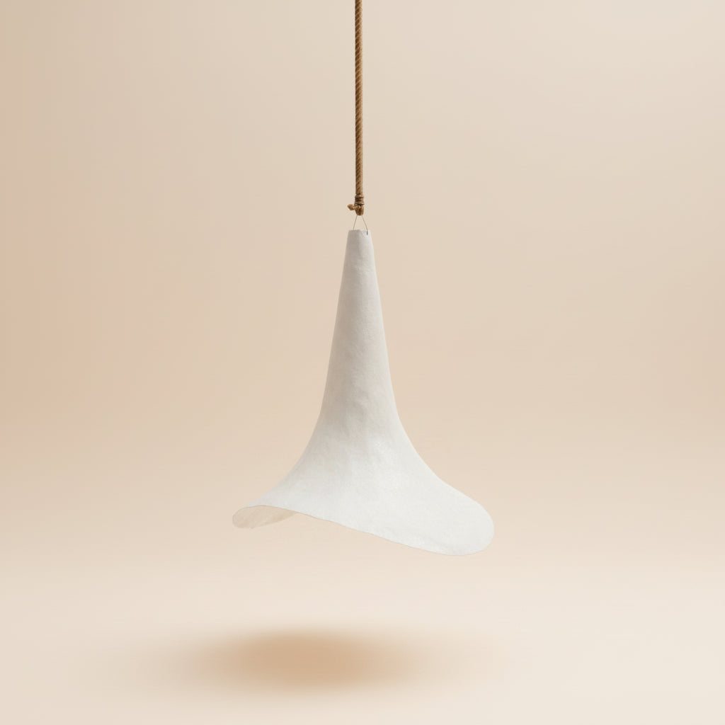 A white, bell-shaped hanging white resin 70cm light . By Bisque Traders, Byron Bay.