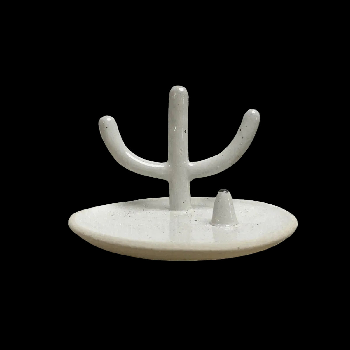 White ceramic wall hook with branch-like design against a textured beige wall.