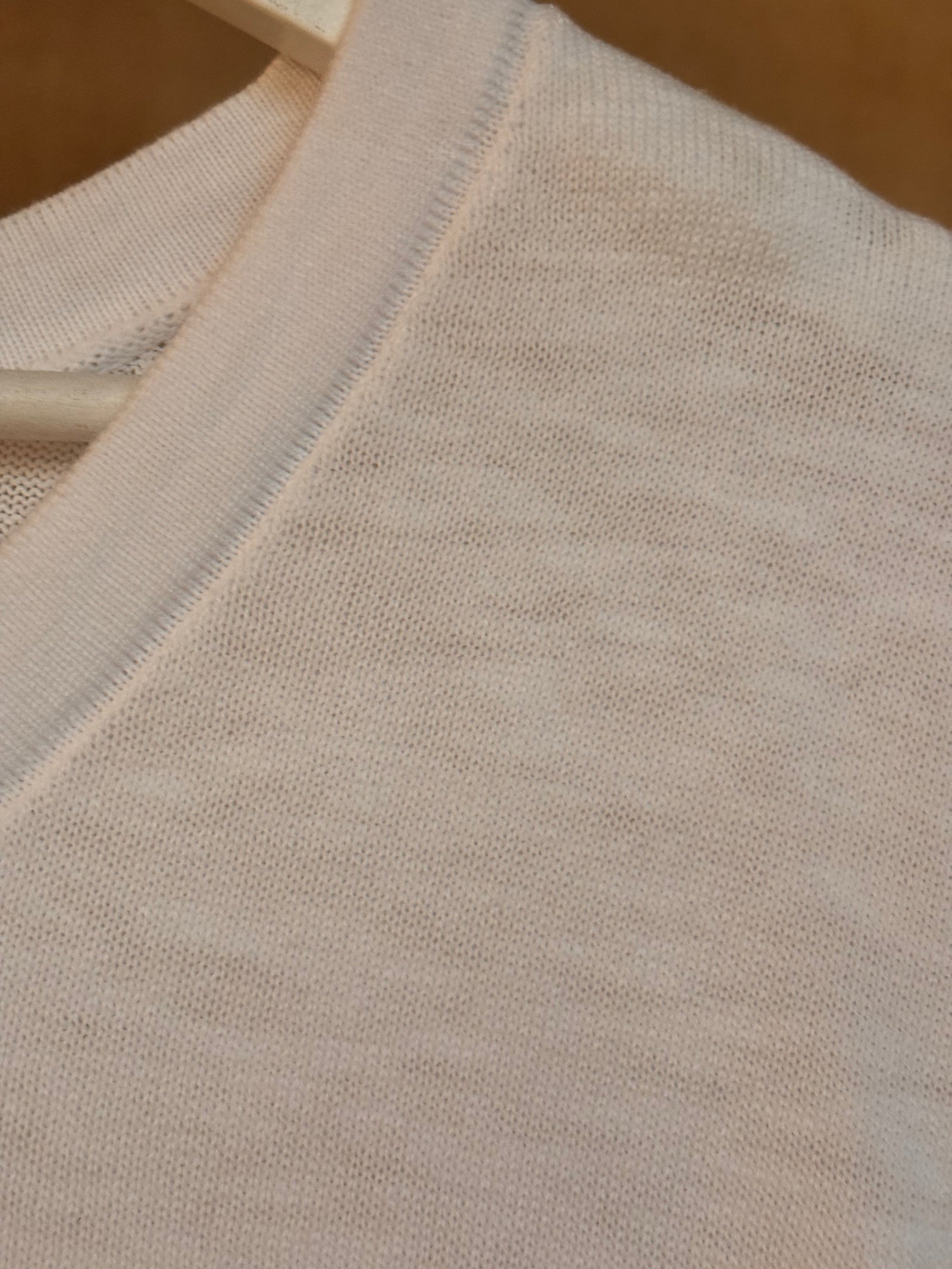 Close-up of white cotton fabric v-neck t-shirt with a textured pattern
