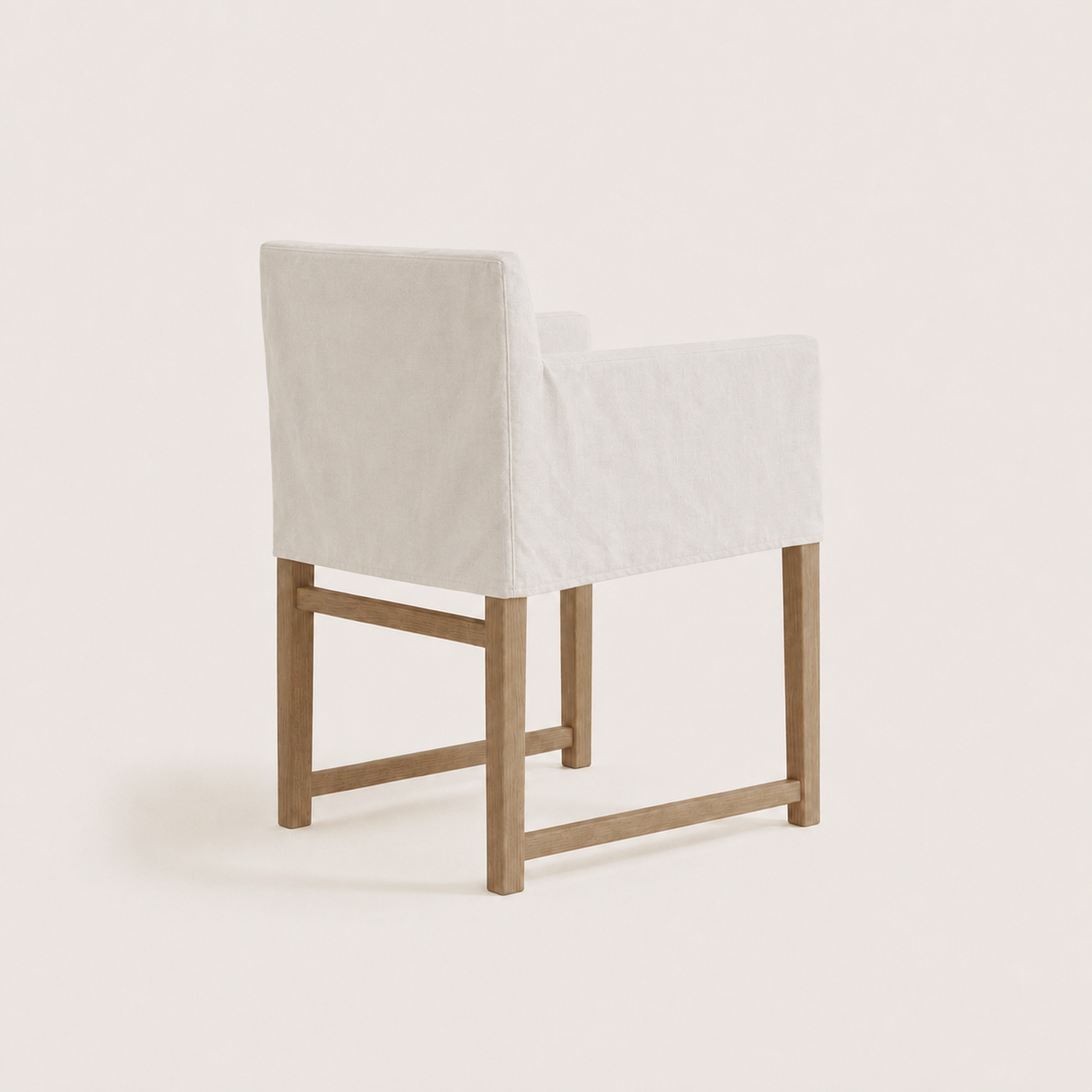 A modern accent chair with a white upholstered seat and backrest, supported by a light natural wood frame, shown against a solid off-white background.