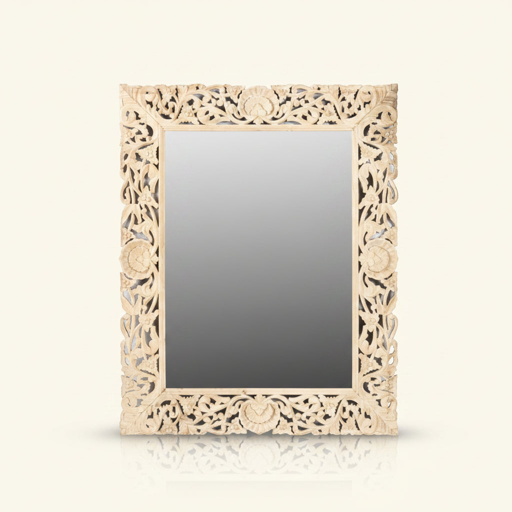 A rectangular mirror with a carved wooden frame featuring floral cut-outs, in a bleached finish.