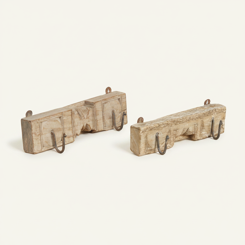 Two rustic carved wooden wall hooks with dark metal hanging loops, displayed on a clean off-white background.