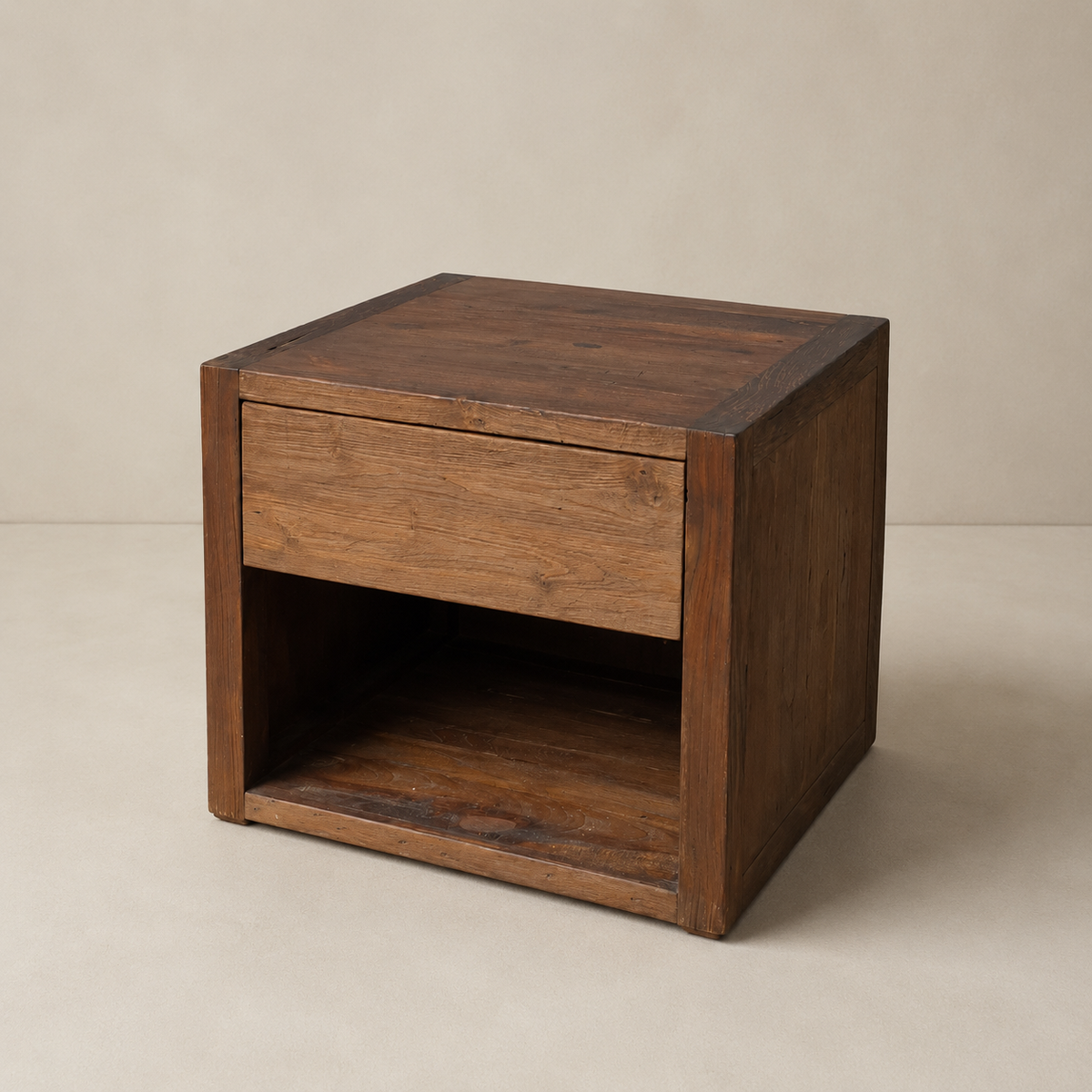A rustic dark brown wooden side table with a single drawer and an open shelf, photographed against a neutral beige background.