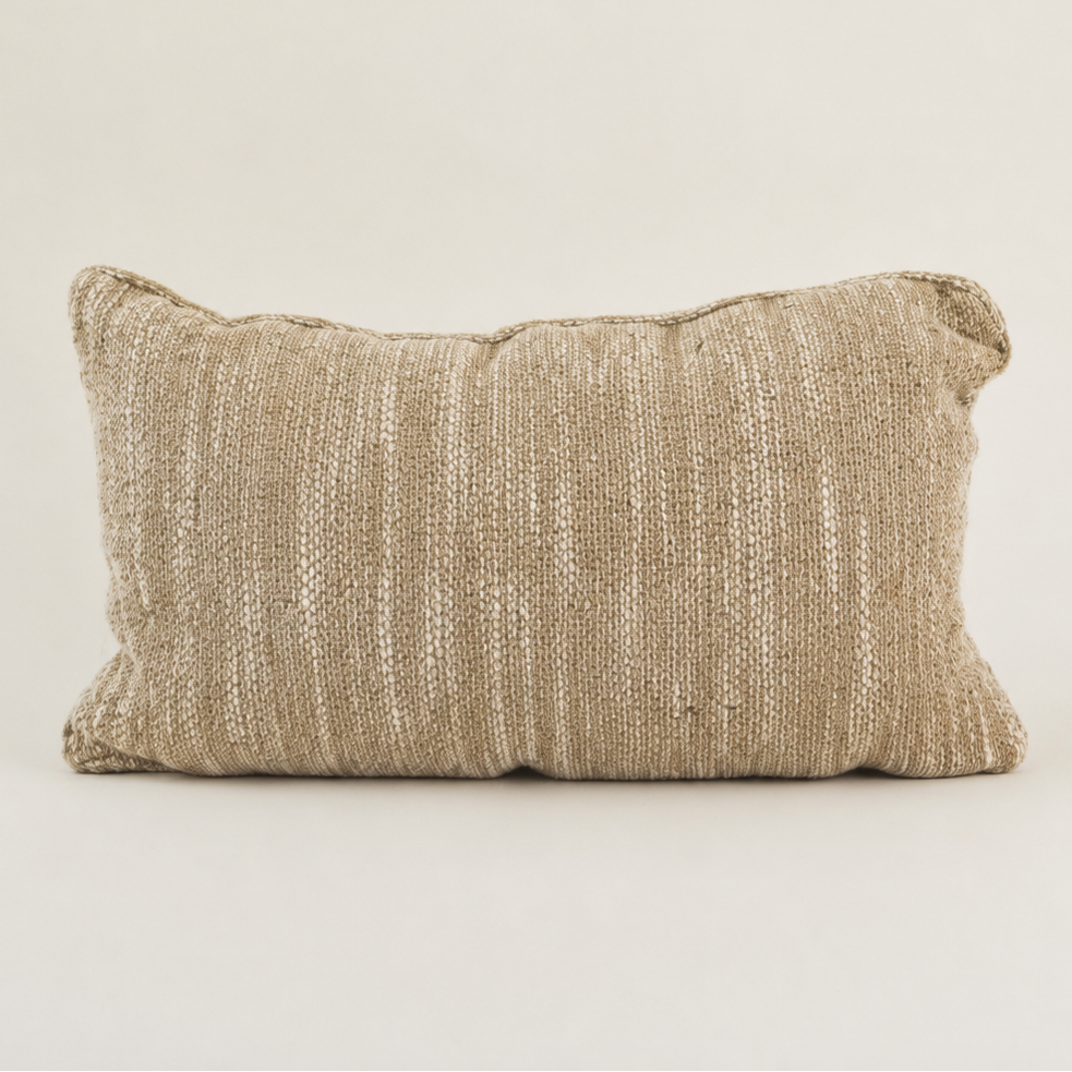 A rectangular lumbar throw pillow in a textured, woven beige fabric, shown against a solid off-white background.