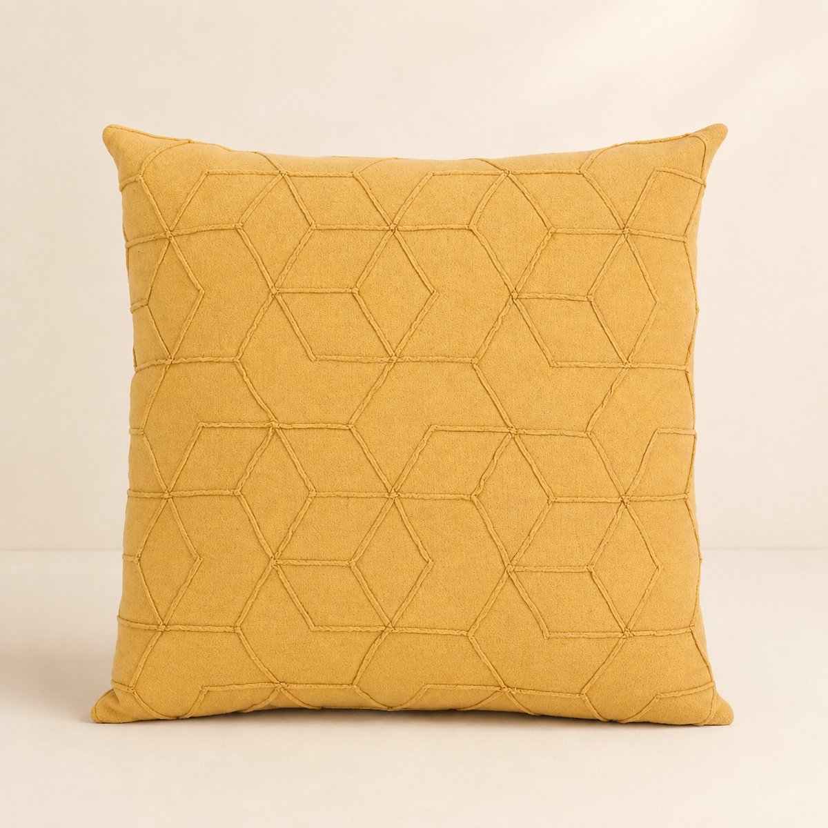 A square yellow throw pillow with a geometric hexagonal stitched pattern, set against a plain beige background.