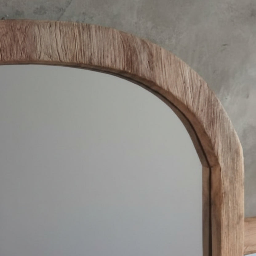 Wooden-framed mirror with a textured wall background