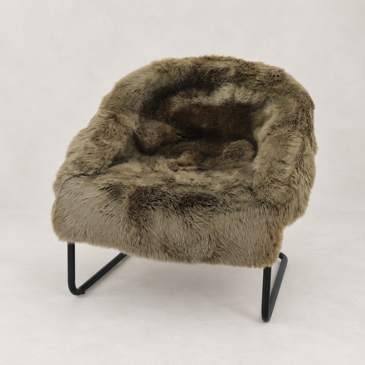 A plush faux-fur lounge chair with a rounded, cushioned seat and back, supported by slim black metal legs, photographed against a neutral light gray background.