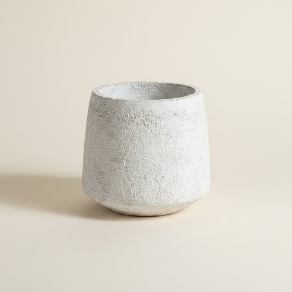 Three textured concrete planters in tapered cylindrical shapes, shown in a close-up shot against a matching textured plaster background.
