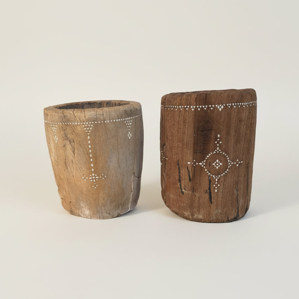 Two wooden planters with decorative patterns on a white wall.