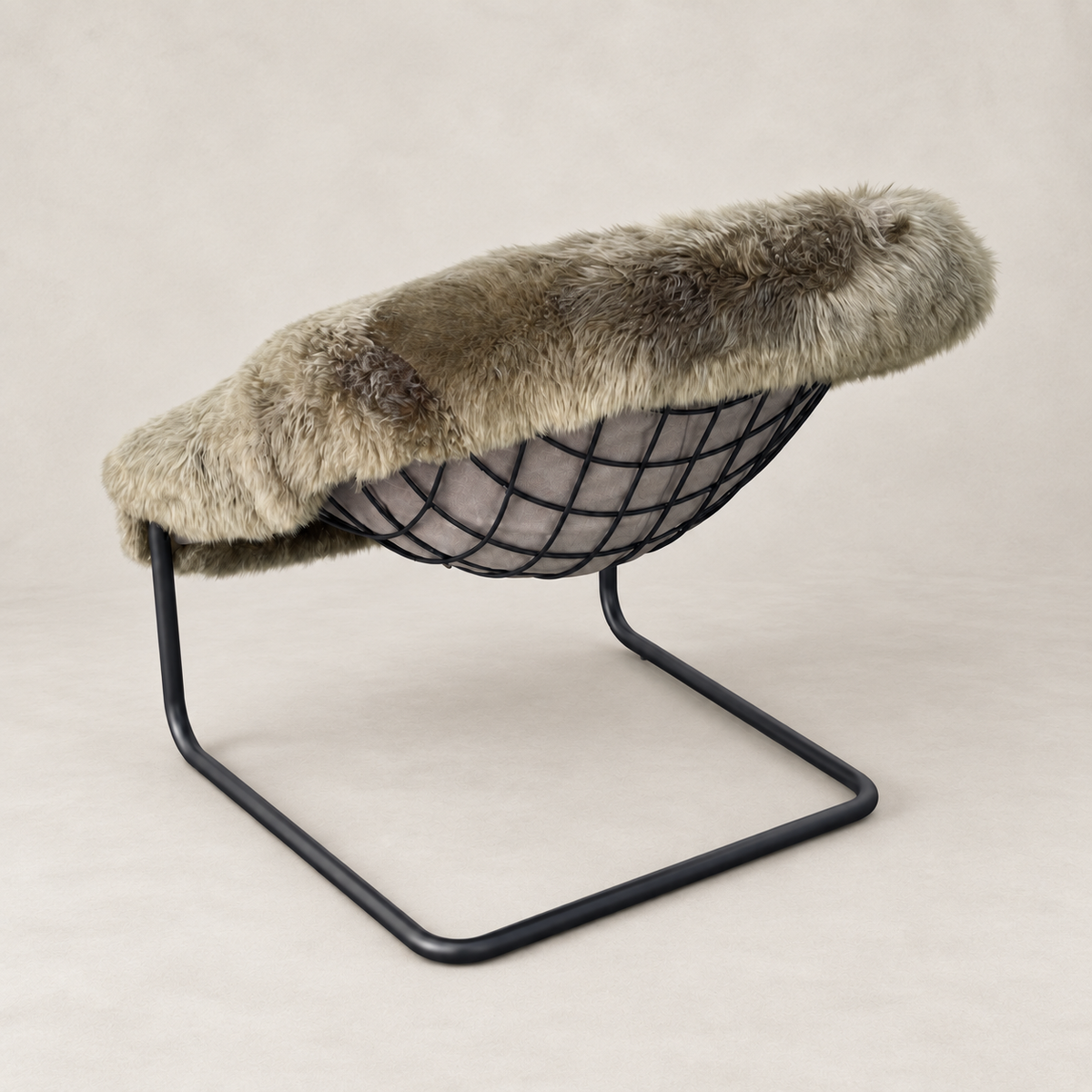 A modern lounge chair with a black wire bowl seat, supported by a black metal U-shaped frame, and topped with a thick, plush taupe-gray faux fur throw.