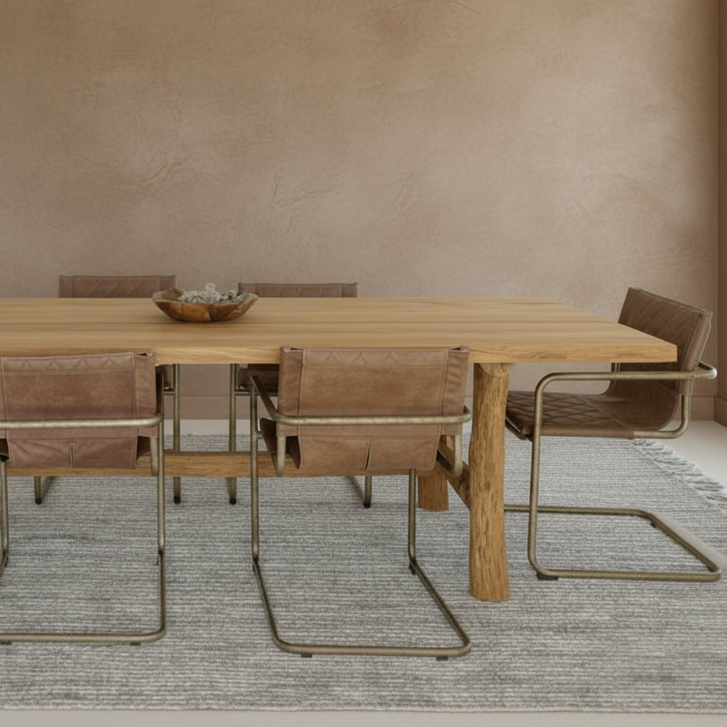 


Dining area with log leg reclaimed wood table and chairs in a room with beige walls and a gray rug.