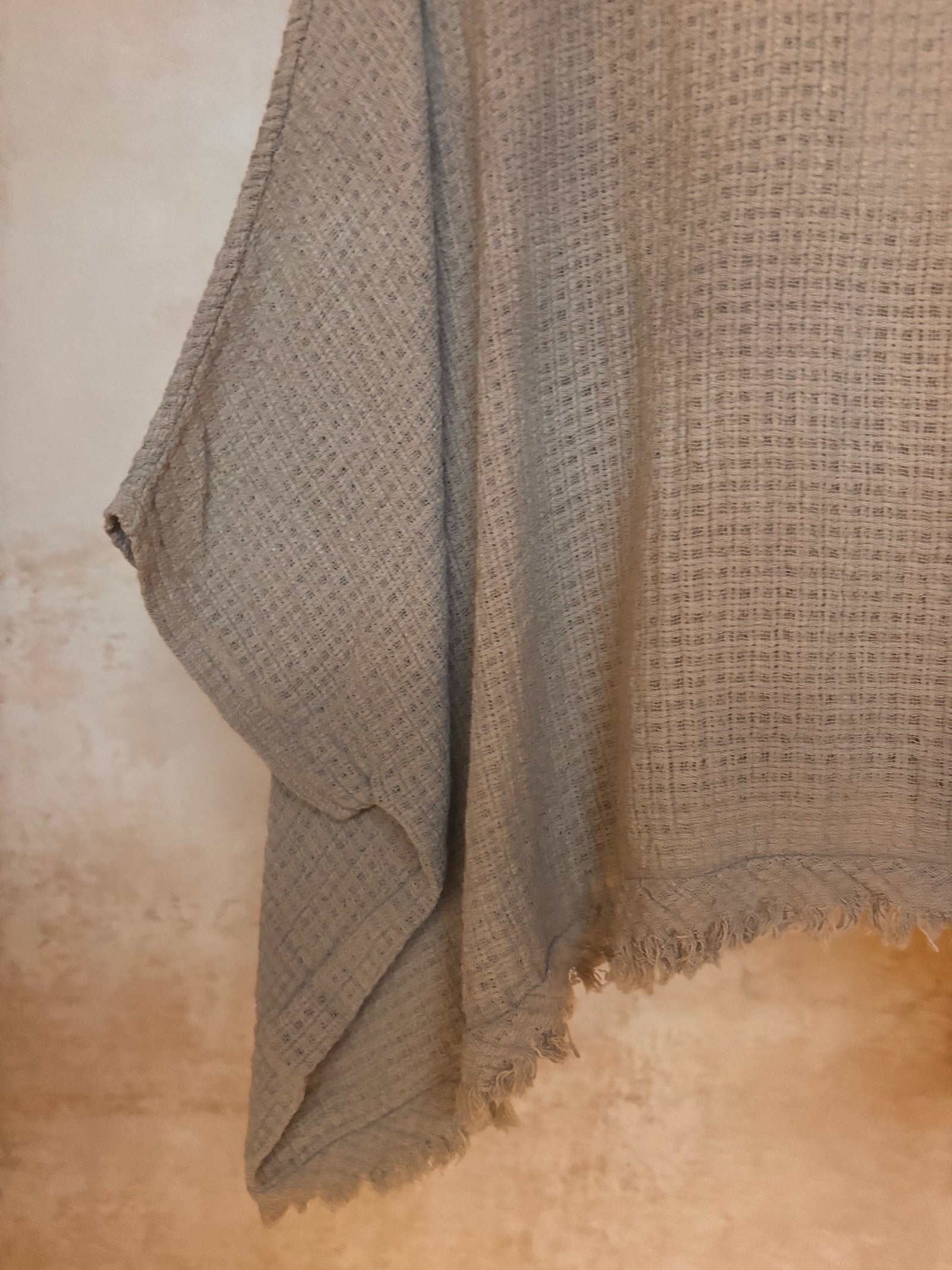 Textured fabric draped over a surface with a neutral background