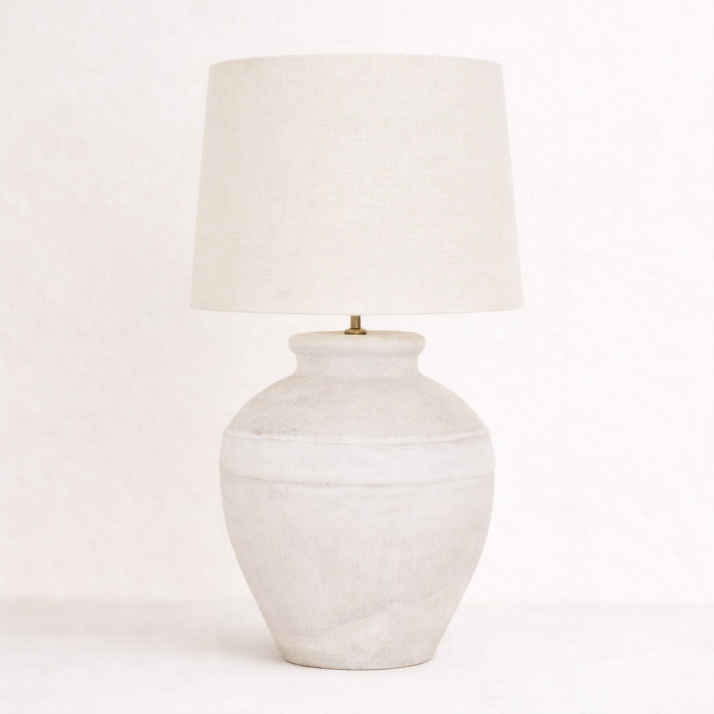 White ceramic table lamp with a beige lampshade on a white background
