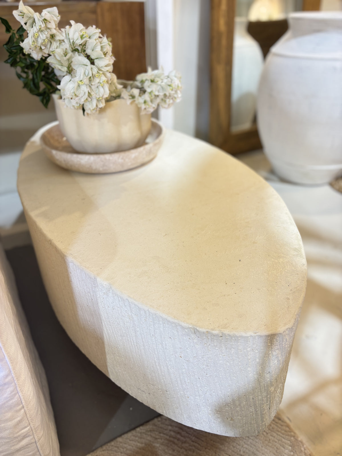 'Elena' GRC oval coffee table with rough stone appearance on the sides.