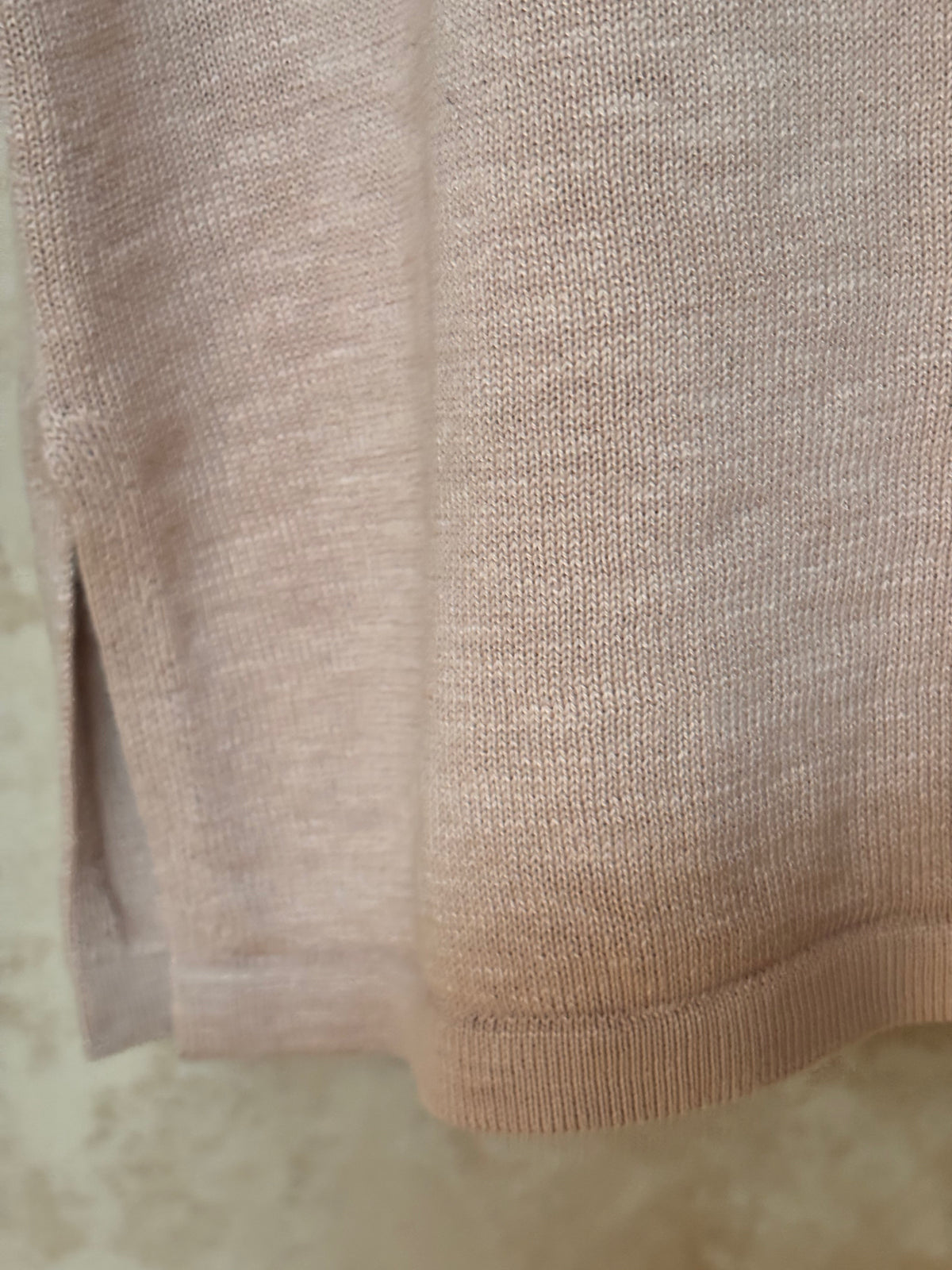 Close-up of beige fabric with a textured pattern on a light background