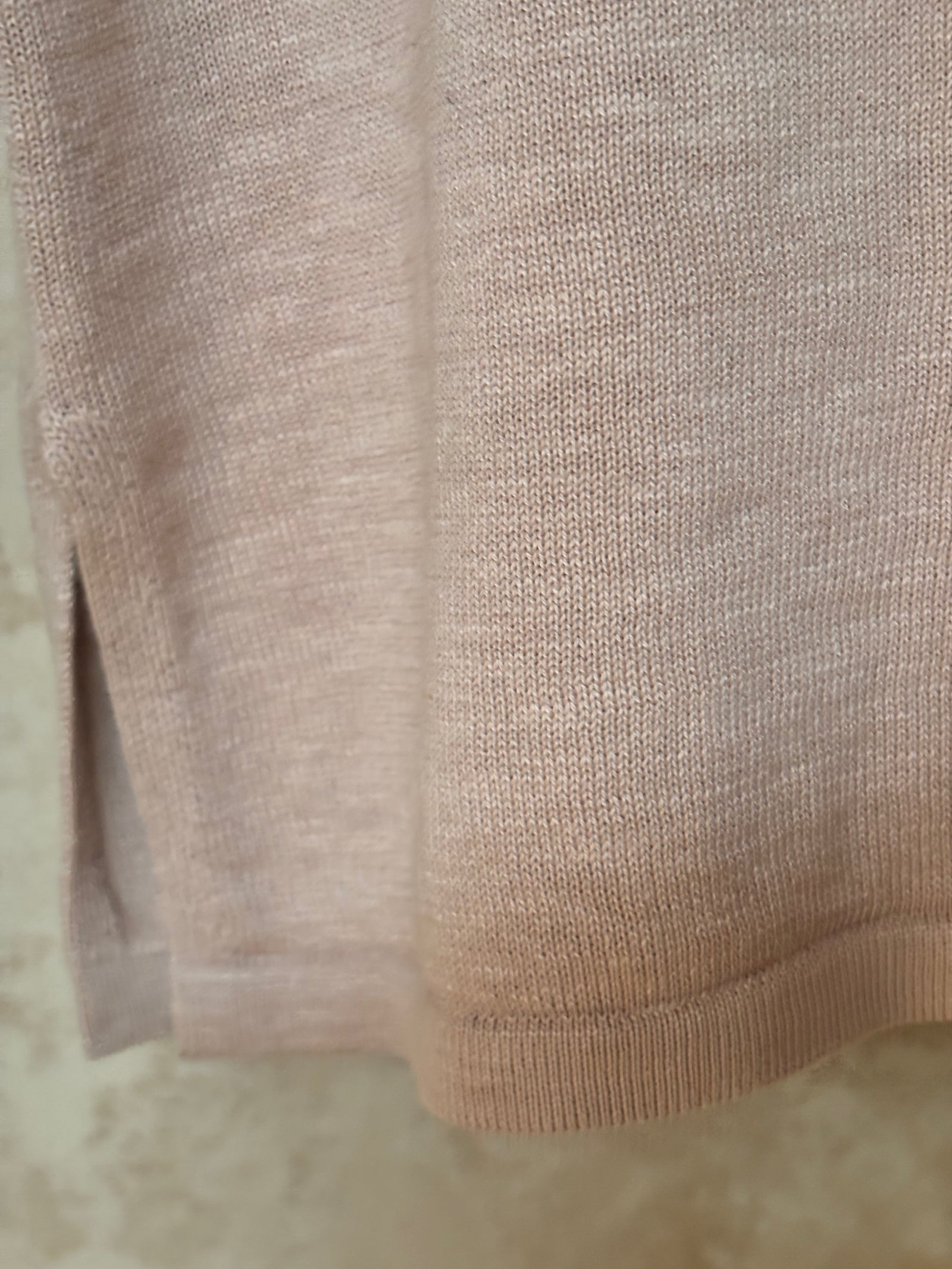 Close-up of beige fabric with a textured pattern on a light background