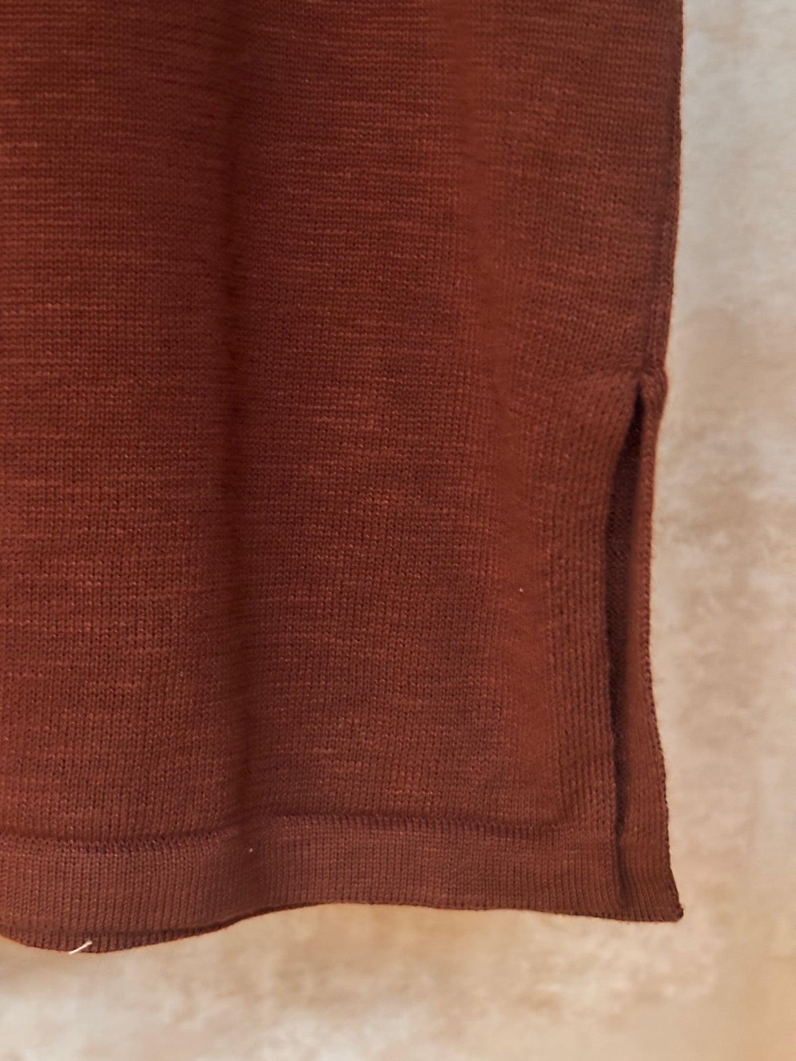 Close-up of a brown textured pure cotton knit fabric tank top on a beige background