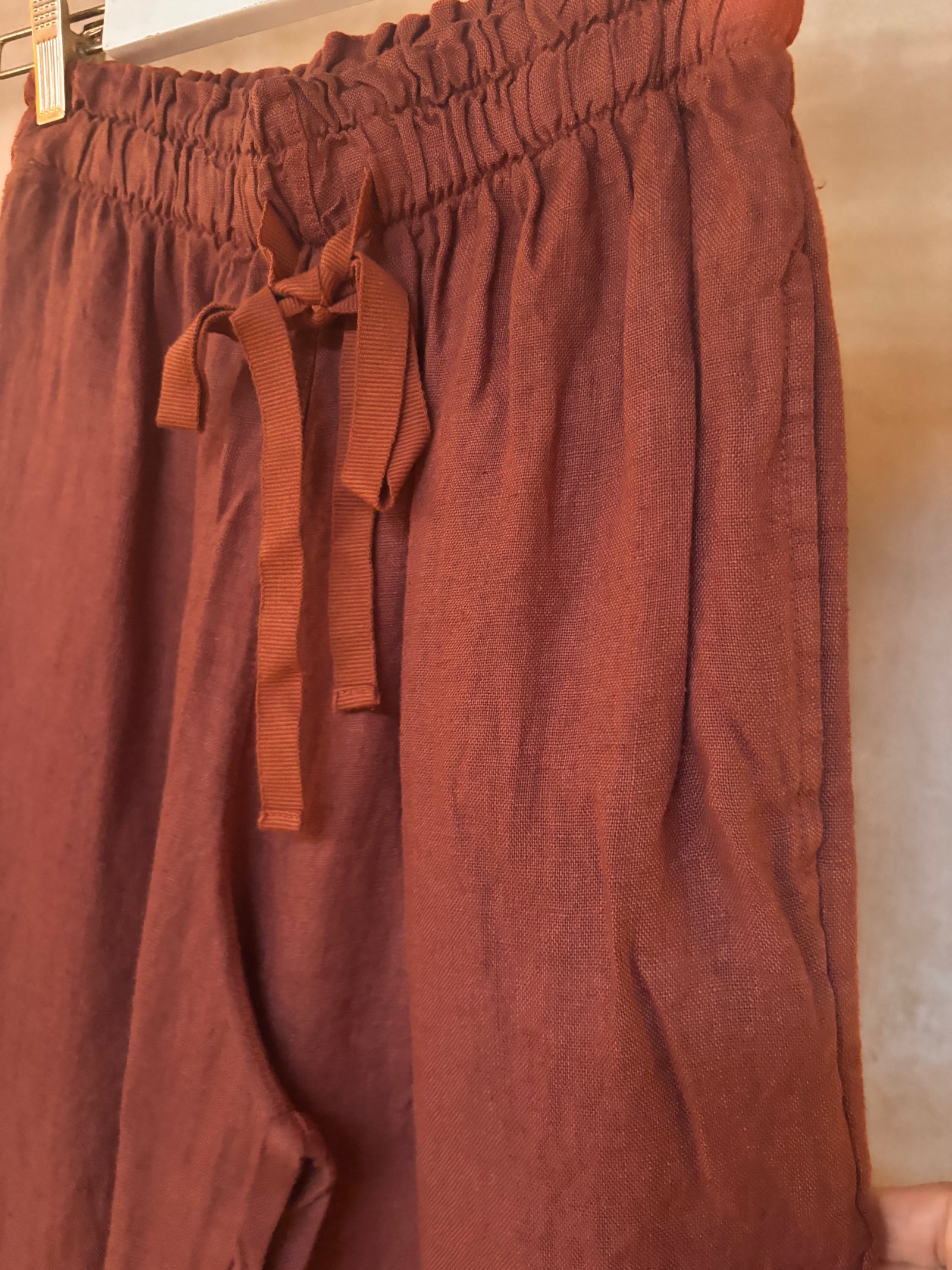 Brown linen Gelso pants with drawstring waistband on a neutral background