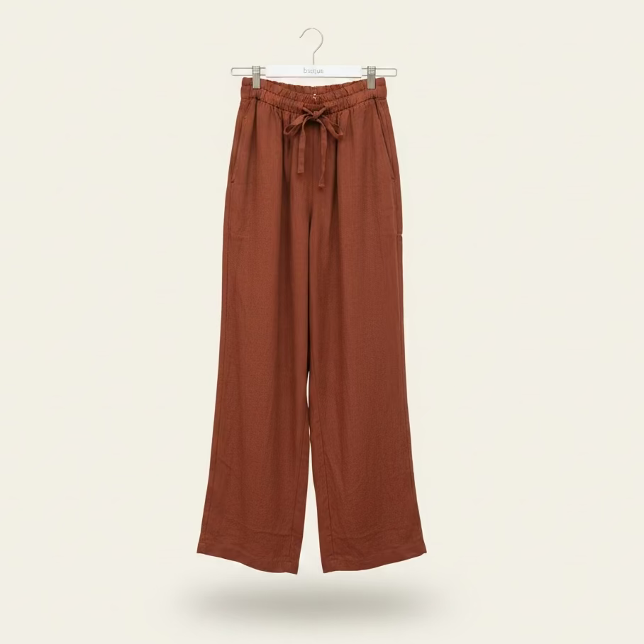 Coco Brown Italian linen gelso pants on a hanger against a beige background