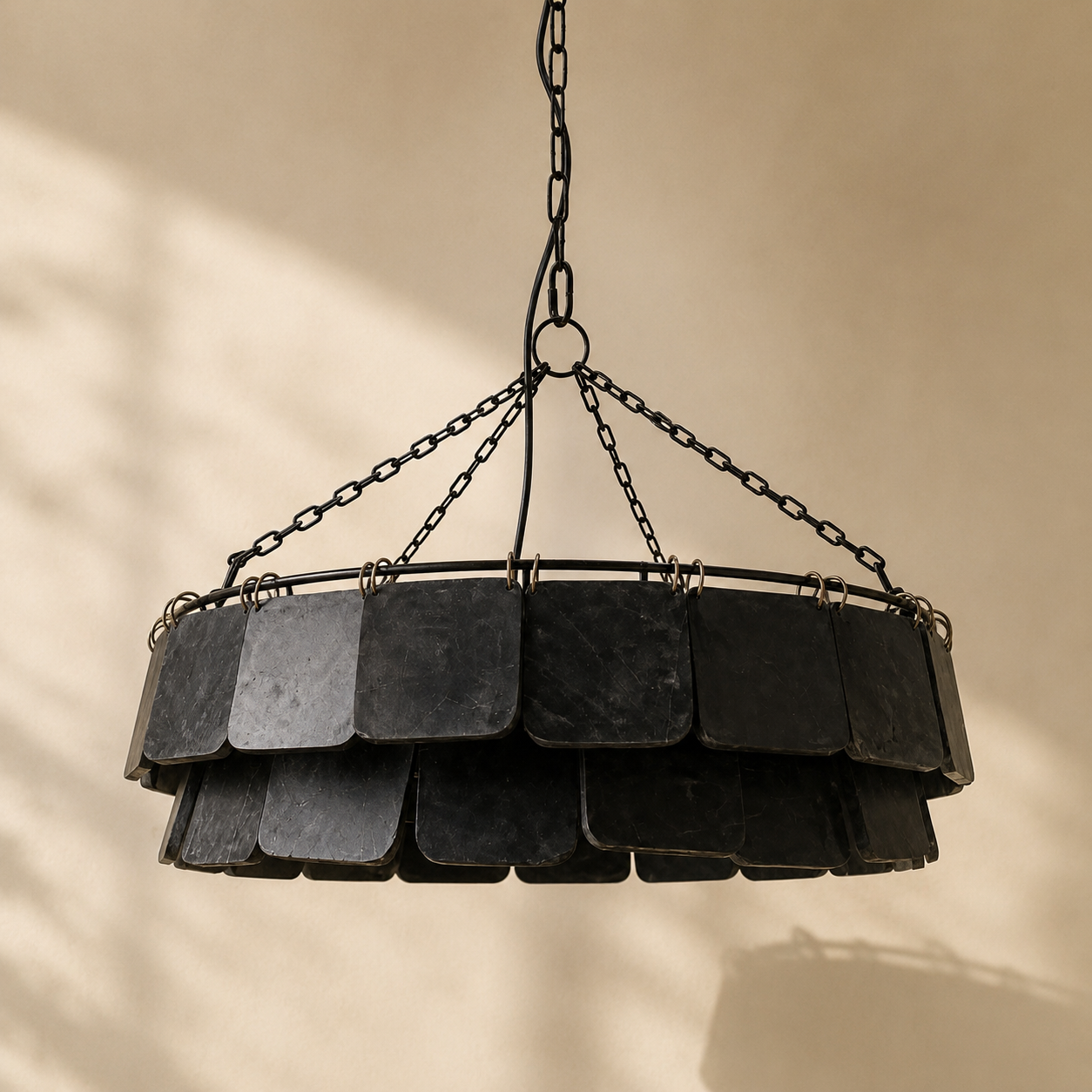 Decorative pendant light with layered black marble squares on a beige background.
