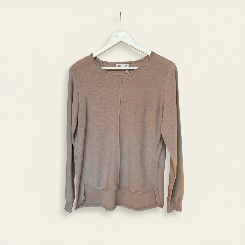 Brown pure cotton knit sweater on a hanger against a beige wall