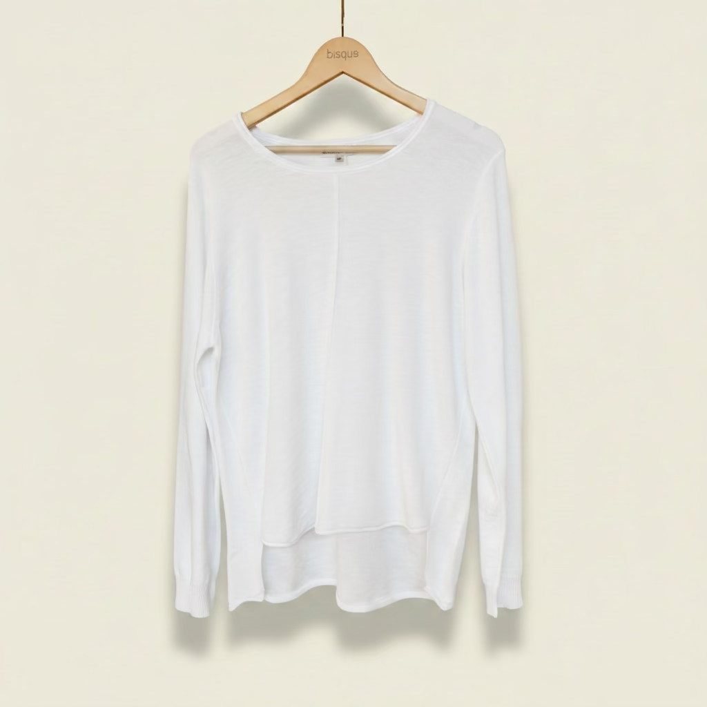 white long-sleeve shirt on a hanger against a textured beige wall