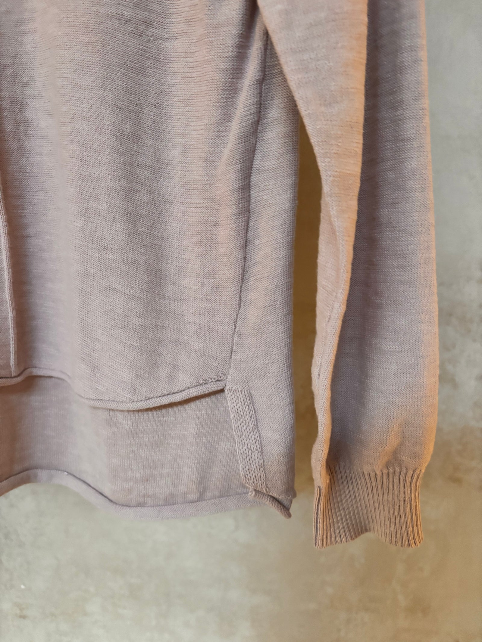 Close-up of a beige pure cotton Kato sweater on a textured surface
