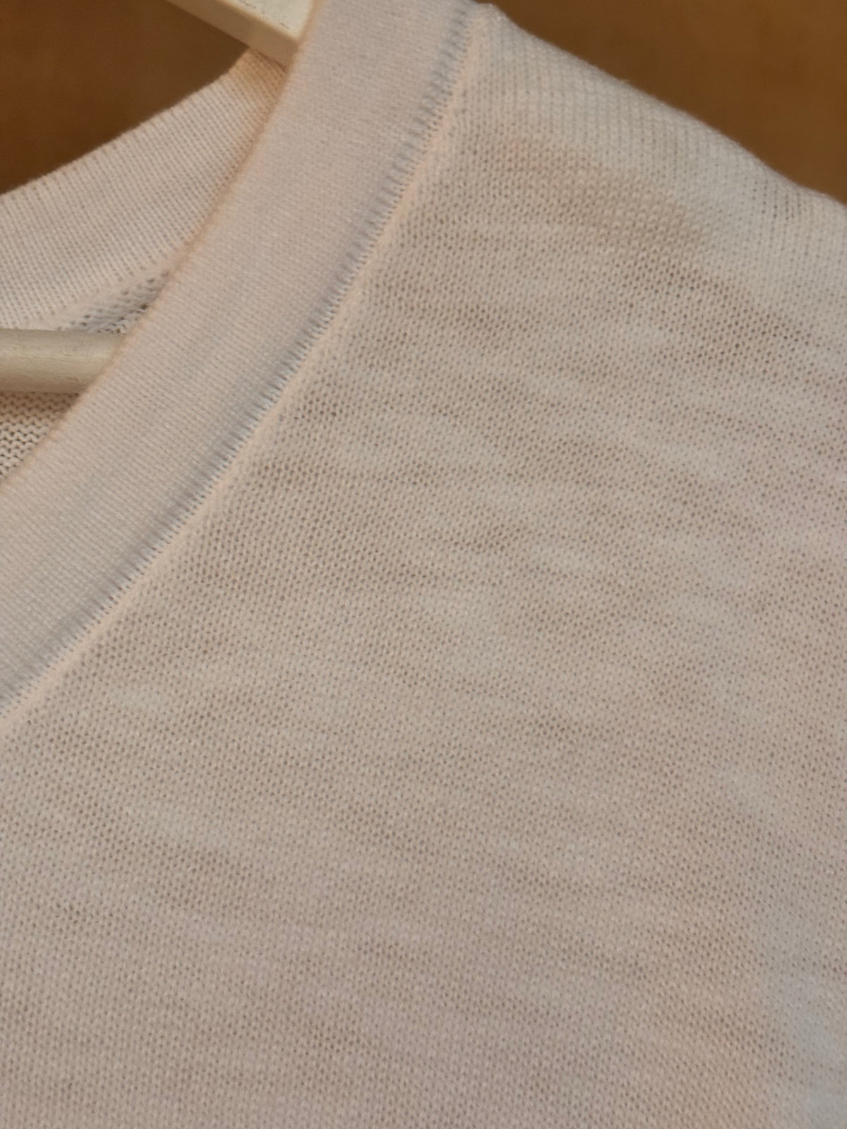 Close-up of white cotton fabric  v-neck t-shirt with a textured pattern