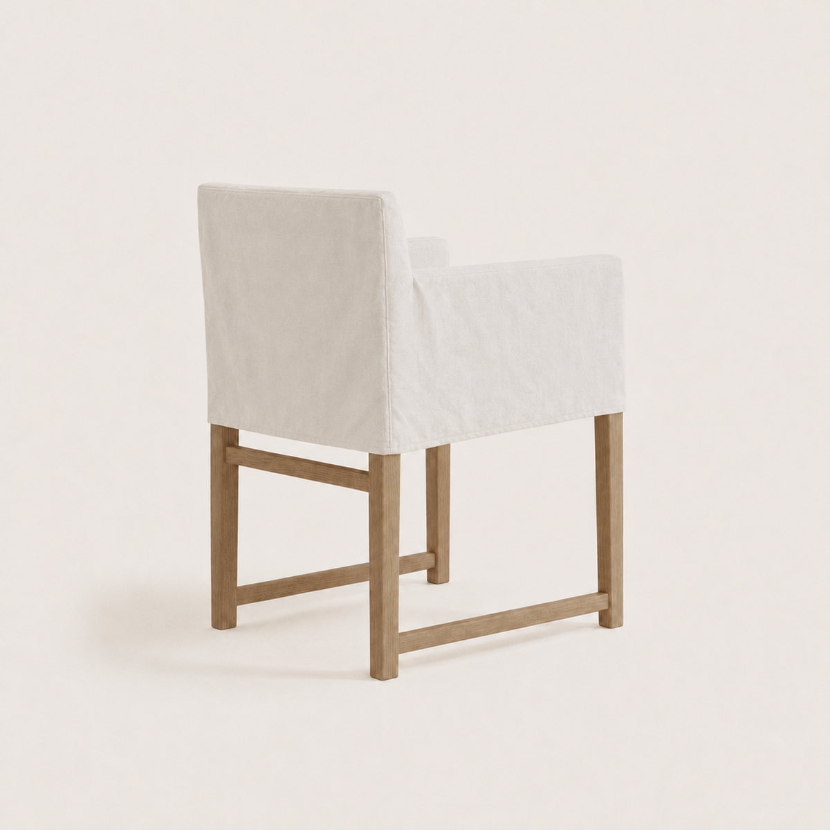 A modern accent chair with a white upholstered seat and backrest, supported by a light natural wood frame, shown against a solid off-white background.