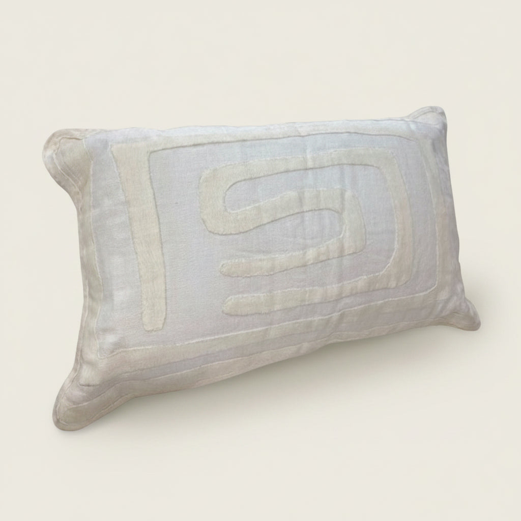 White pillow with a quilted design on a light gray background