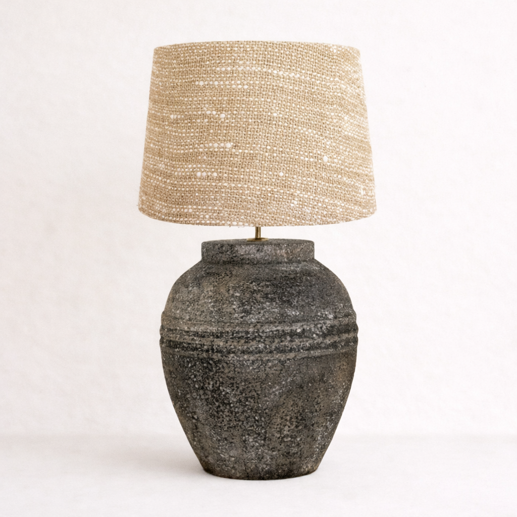 Table charcoal fat lamp with textured base and beaded lampshade on a white background