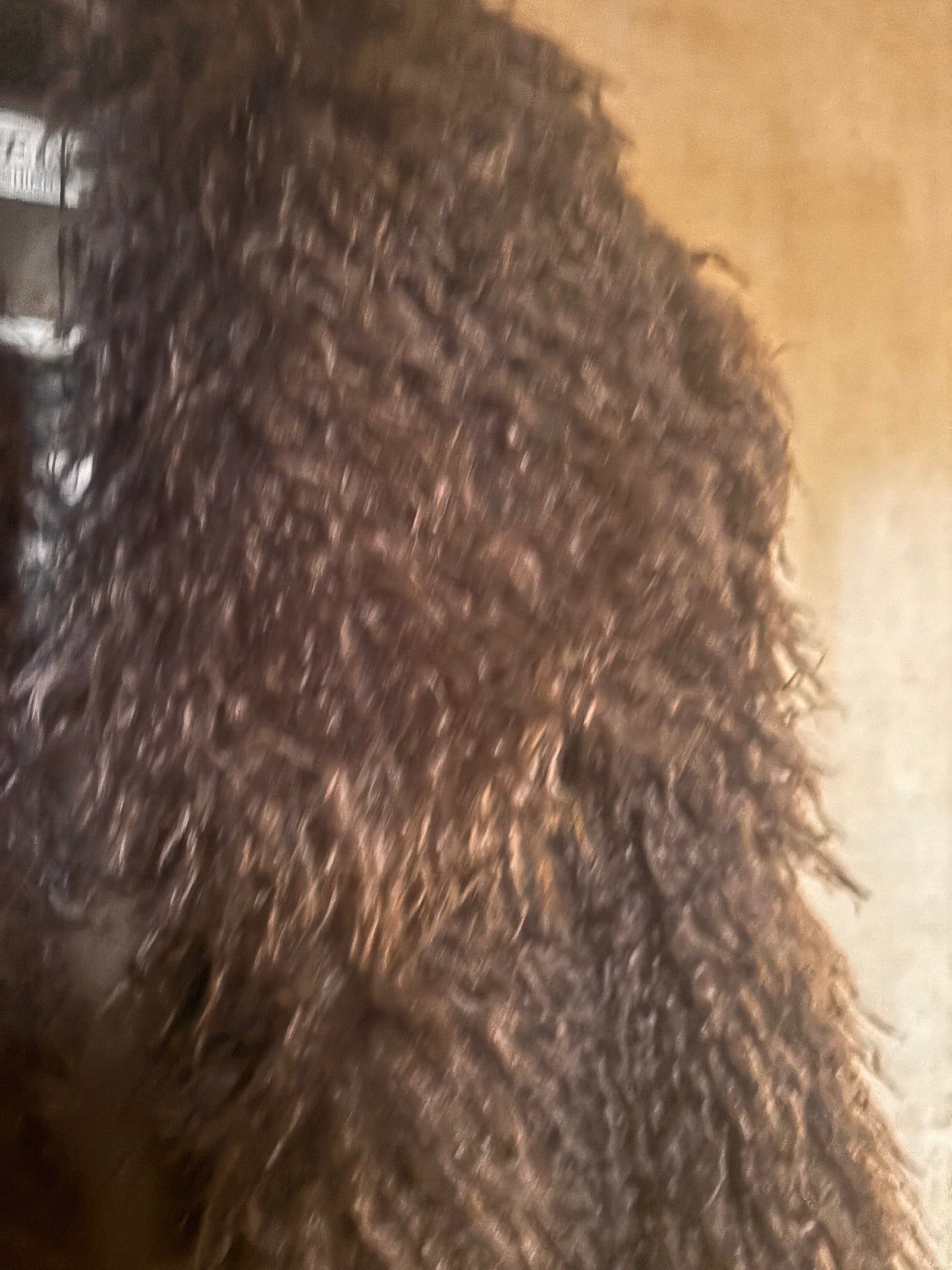 Close-up of a textured faux fur mink vest, brown.