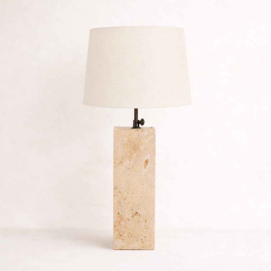 Table lamp with a fossilised coral base and a white lampshade on a light pink background