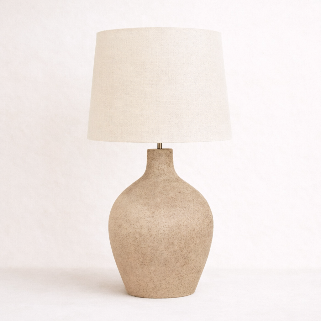 Beige terracotta table lamp with a white shade on a light pink background
