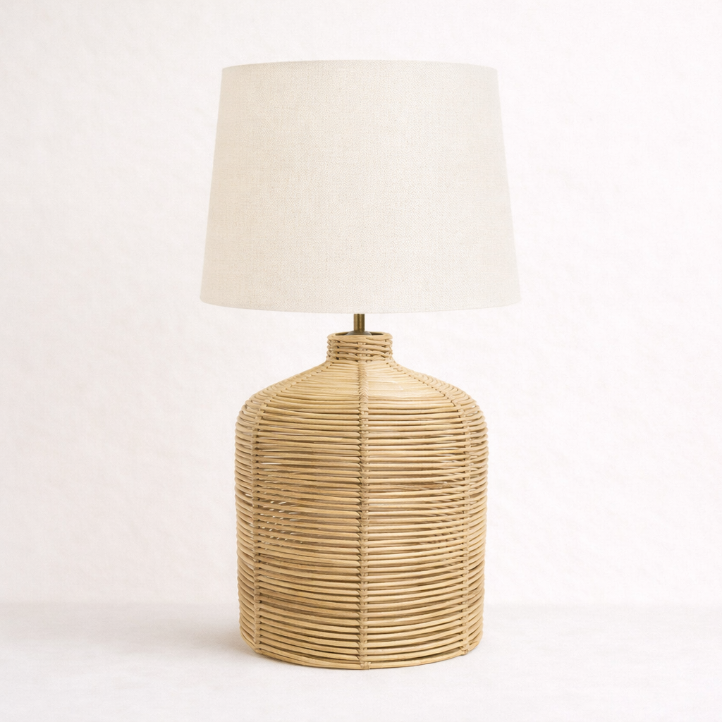 Lamp with rattan woven base and white shade on a light background