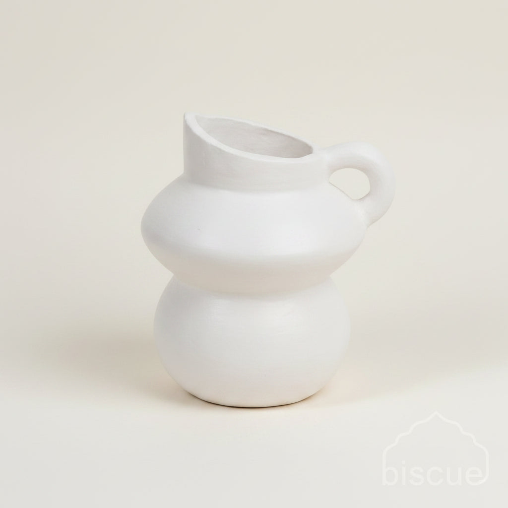 White terracotta pitcher on a textured beige wall