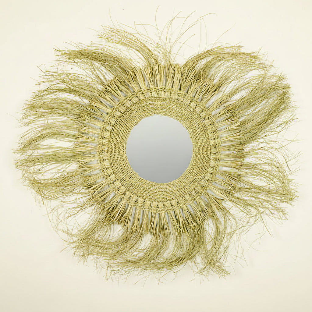 A round raffia mirror with a beige frame and a mirror in the center.
